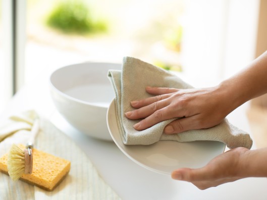 Un plato siendo secado con un pa&ntilde;o en la cocina